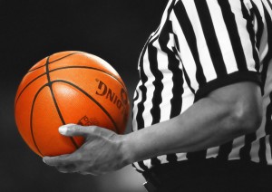 referee holds basketball